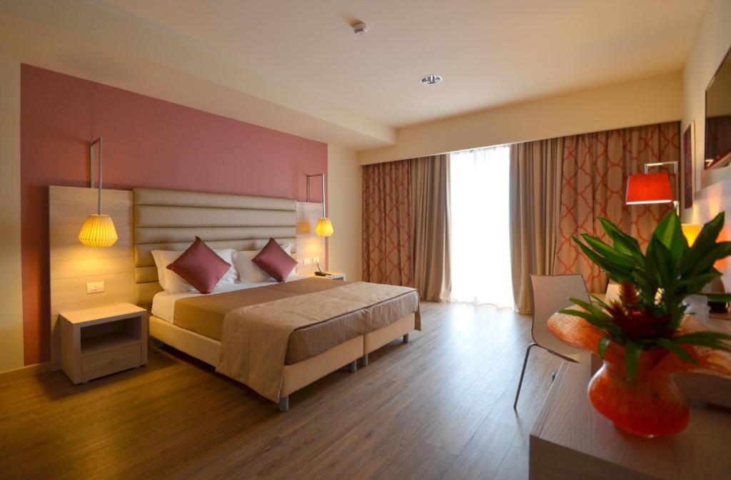 ein Schlafzimmer mit einem großen Bett in einem Zimmer in der Unterkunft Turin Airport Hotel & Residence in San Francesco al Campo
