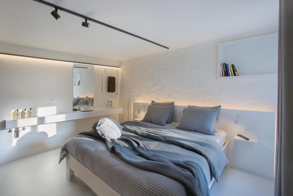 - une chambre blanche avec un lit et un miroir dans l'établissement Snooz Ap Holiday & Business Flats, à Gand