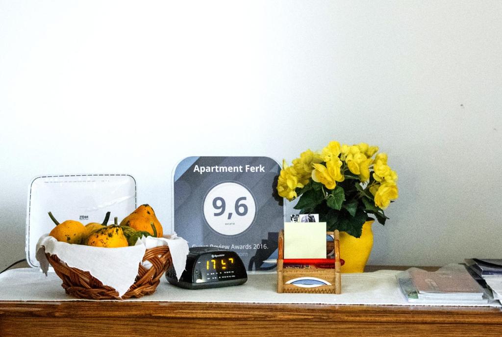 una mesa con reloj y un jarrón de fruta en Apartment Ferk, en Zagreb