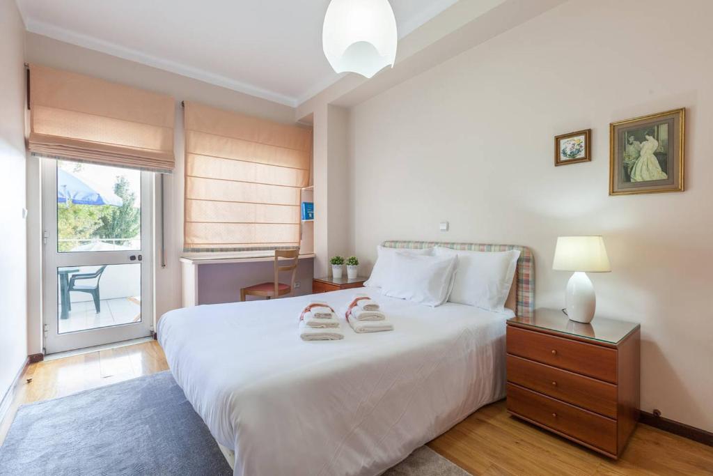 ブラガにあるRH Charming Apartment São Victorのベッドルーム(大きな白いベッド1台、窓付)