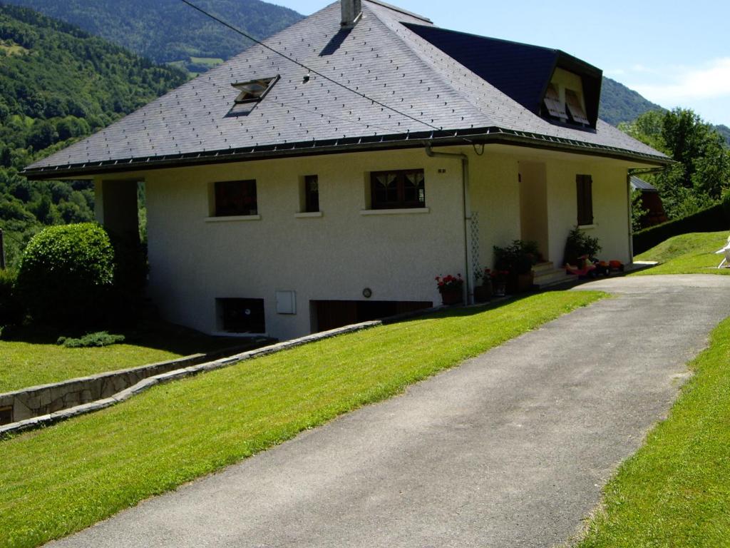 a white house with a grey roof and a driveway at Chambres d'Hôtes Les Pierres Taillées in Thénésol