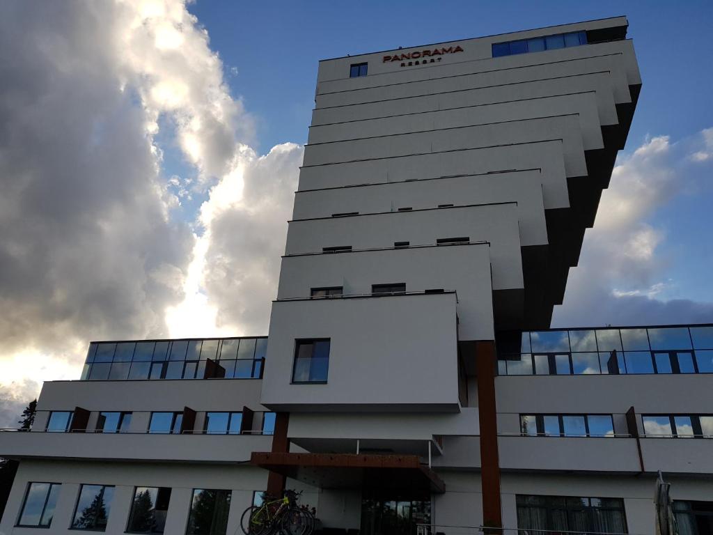 a tall white building with a billboard in front of it at Apartmán Panorama 308 in Štrbské Pleso