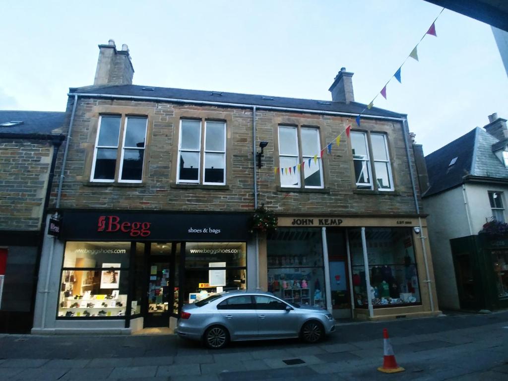 a small car parked in front of a building at Albert Street Apartment in Kirkwall