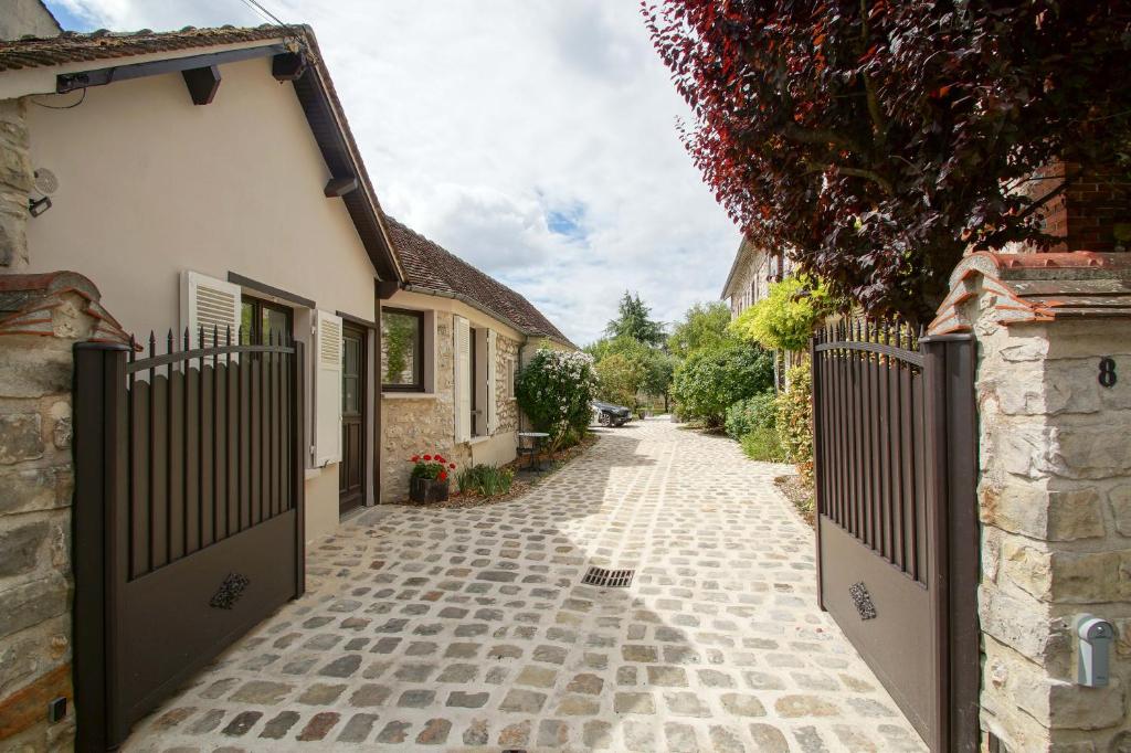 an alley with a gate in front of a house at La Petite Madame in Moret-sur-Loing