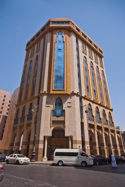 a building with a van parked in front of it at Diyar Taiba Hotel in Medina