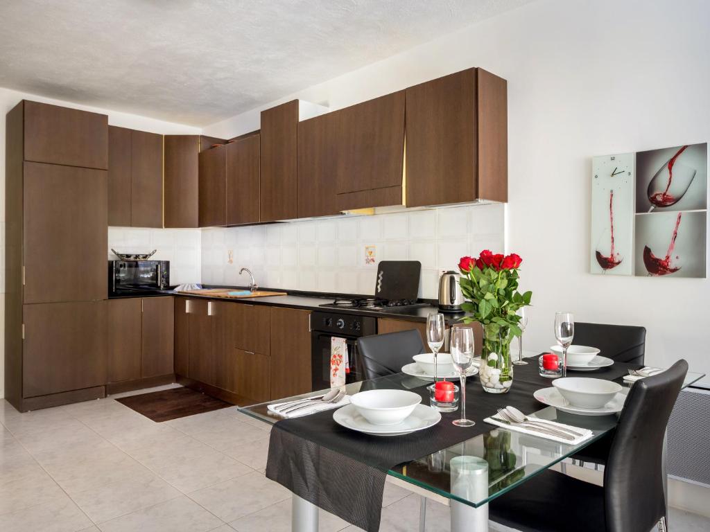 a kitchen with a table with chairs and a counter top at Apartment 14 in St Paul's Bay