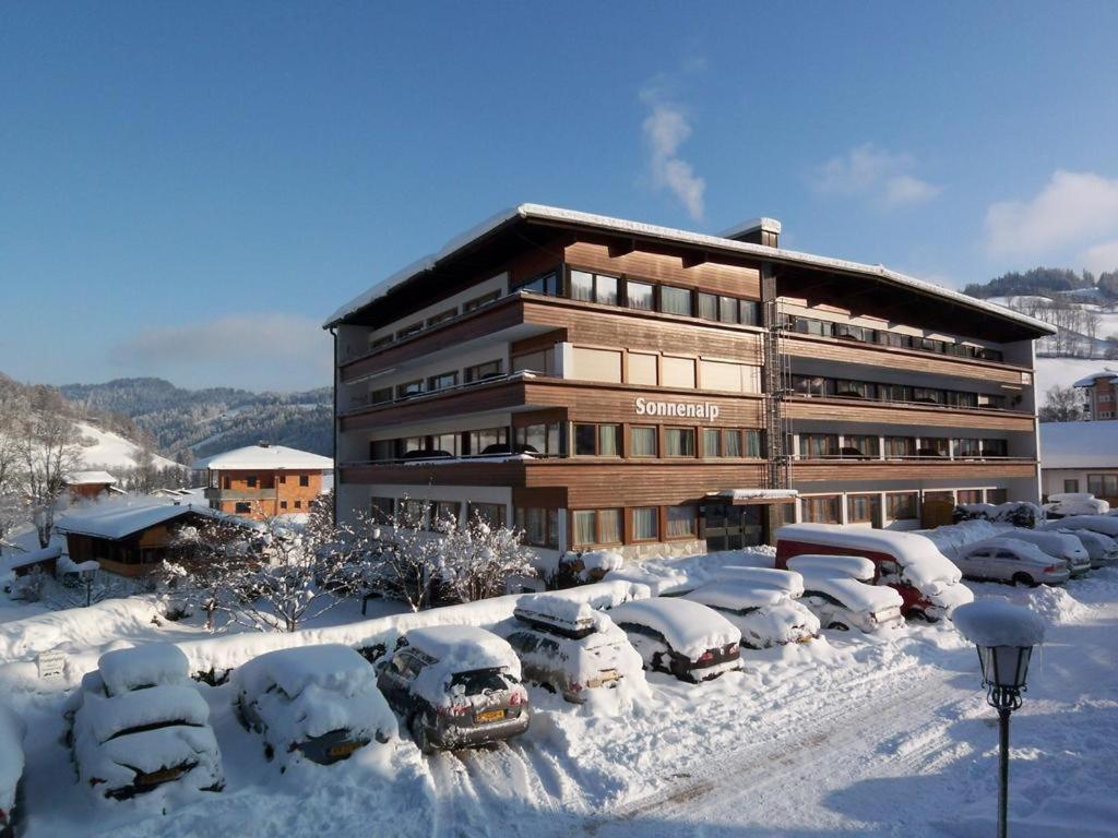 ニーデラウにあるSonnenalp Niederauの雪に覆われた駐車場に車を停めた建物