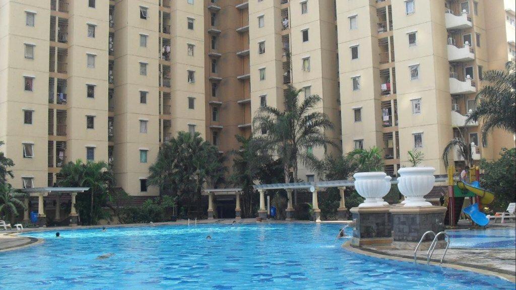 a large swimming pool in front of two tall buildings at Mediterania palace residences kemayoran in Jakarta