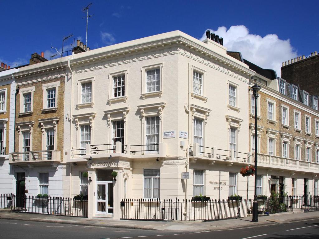 a white building on the corner of a street at The Grapevine Hotel in London