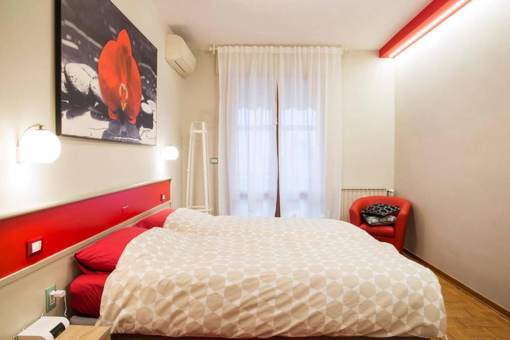 1 dormitorio con 1 cama y 1 silla roja en Le Petit Monde - Eleganza e relax in centro a Abano Terme, en Abano Terme