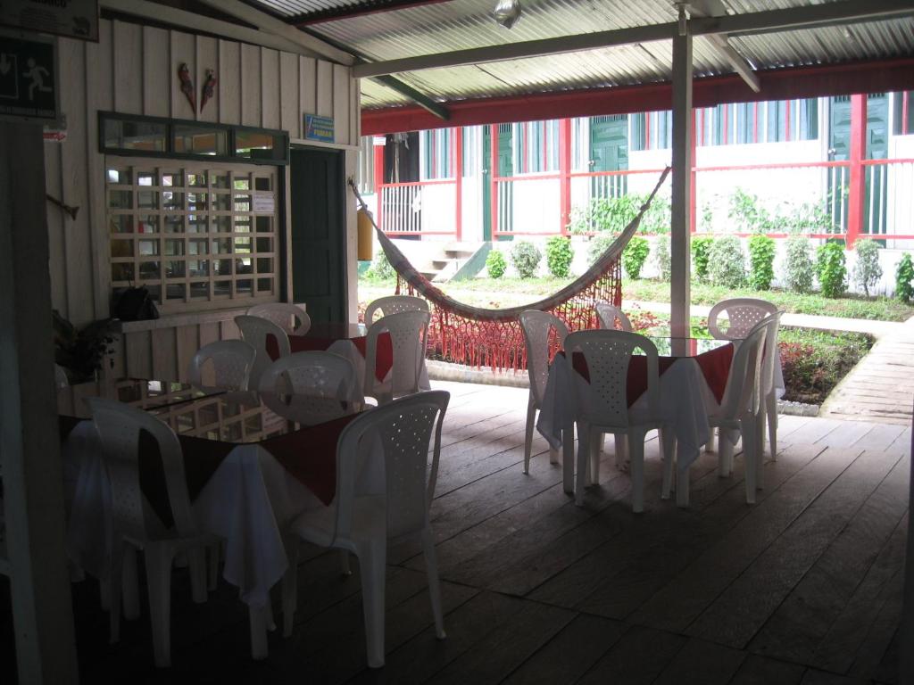 une salle à manger avec des tables et des chaises dans un bâtiment dans l'établissement Hotel Lomas del Paiyü, à Puerto Nariño