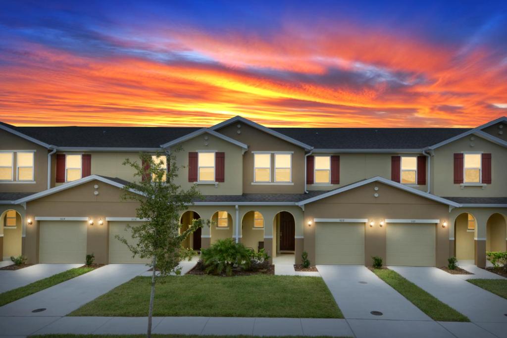 une maison avec un coucher de soleil en arrière-plan dans l'établissement Four Bedrooms Townhome 5108K, à Kissimmee