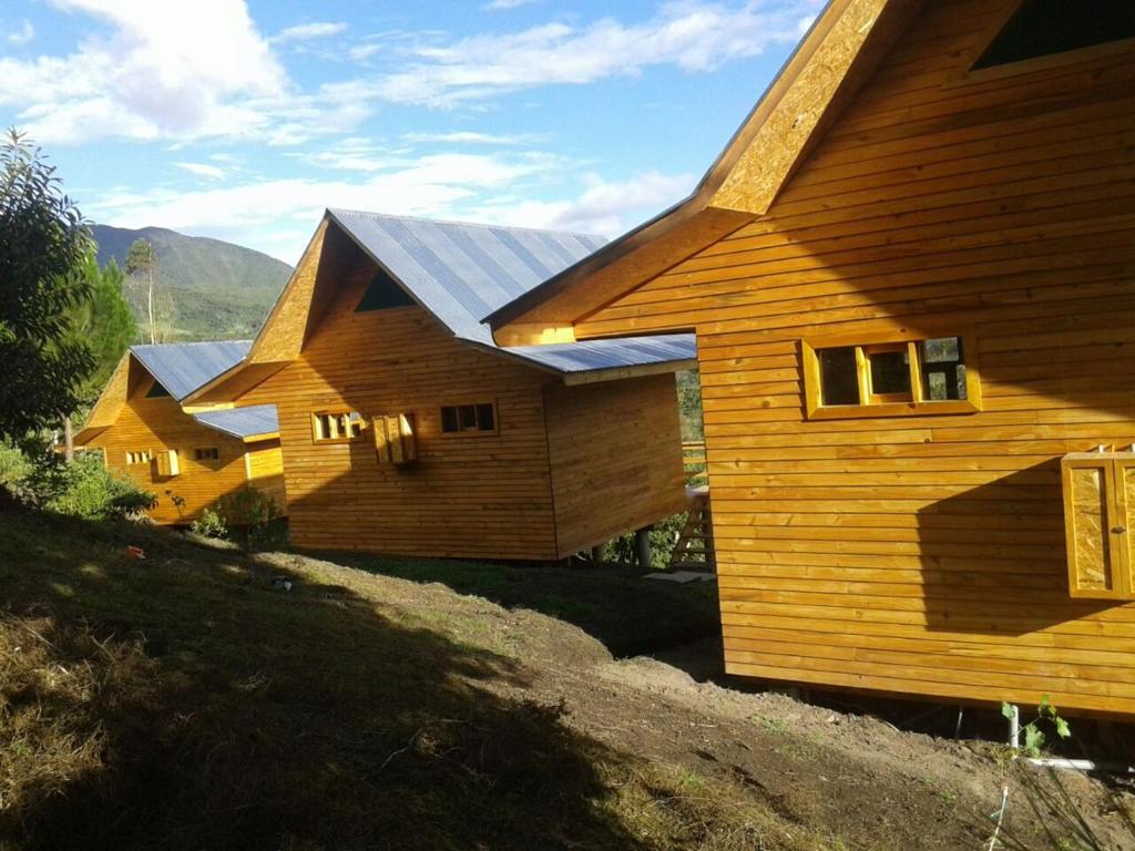 un grupo de casas de madera con paneles solares. en San Alberto Ecolodge, en Oxapampa