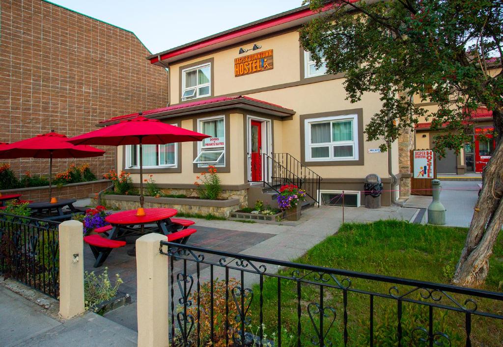 a restaurant with tables and umbrellas in front of a building at Jasper Downtown Hostel in Jasper
