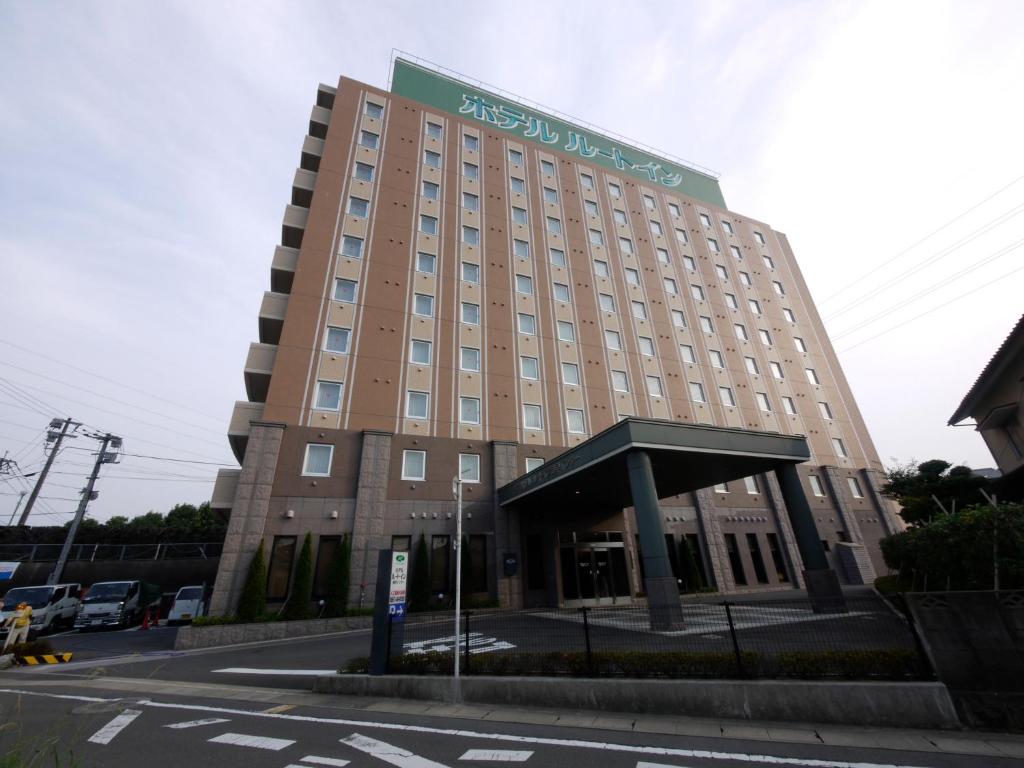 a large building with a sign on the front of it at Hotel Route-Inn Isahaya Inter in Isahaya
