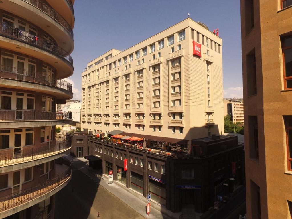 葉瑞文的住宿－宜必思埃里溫中心酒店，一座高大的白色建筑,上面有红旗