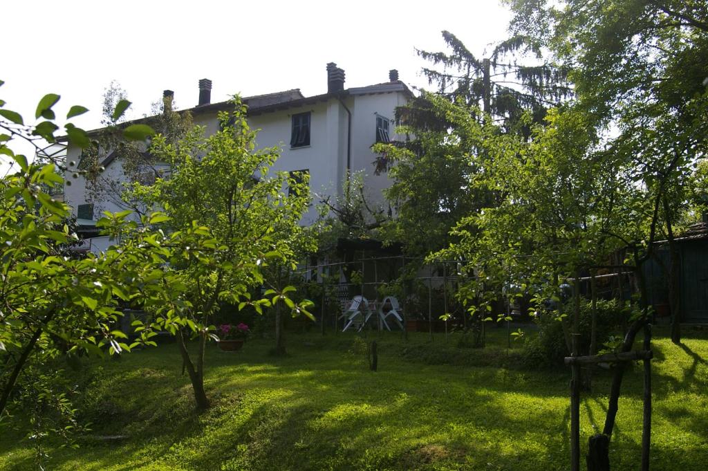 a white house with trees in the yard at Ca' di Croso' in Riccò del Golfo di Spezia