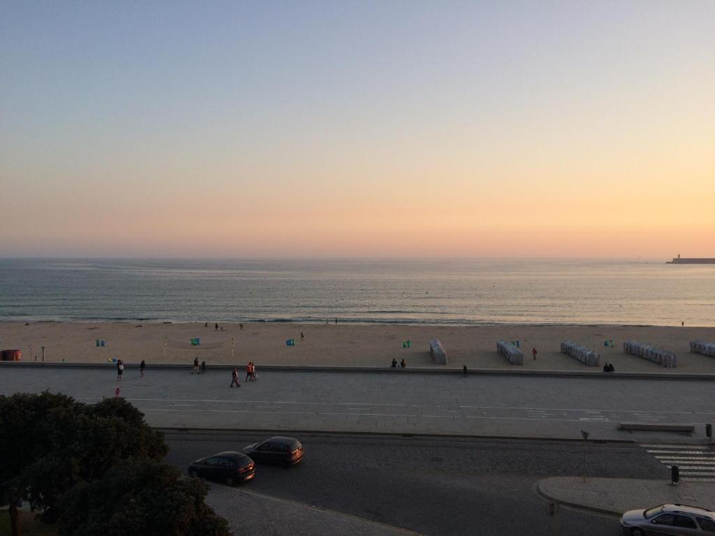 uma vista para uma praia com pessoas e para o oceano em Oporto beach apartment em Matosinhos