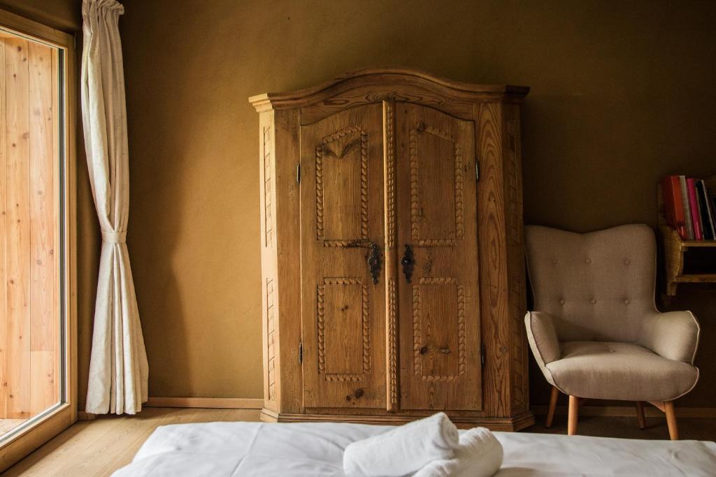 1 dormitorio con armario de madera y silla en Weingut Georgium, en Sankt Georgen am Längsee