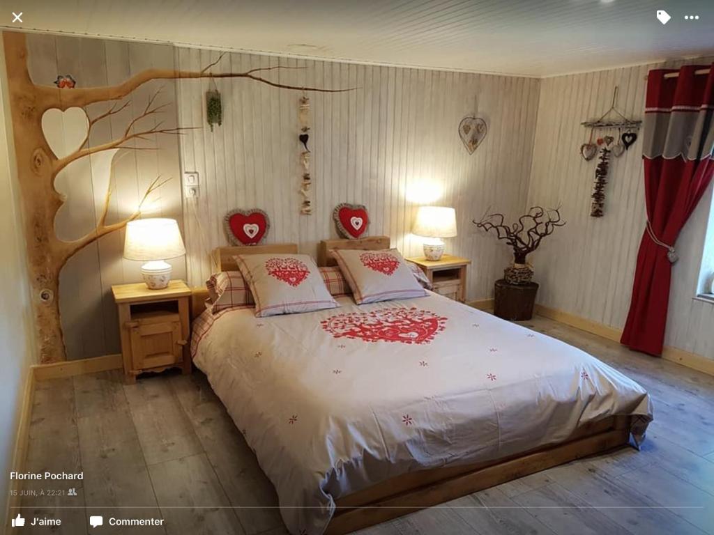 Un dormitorio con una cama con corazones rojos. en La Ferme de Là-haut B&B en Le Haut-du-Them