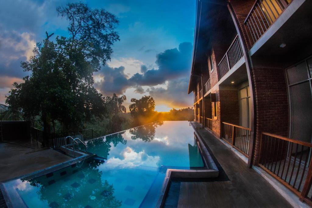 un reflejo del cielo en una piscina al atardecer en Somerset Mirissa en Mirissa