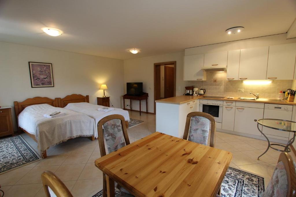 uma cozinha com uma cama e uma mesa num quarto em Rosat 3 em Château-d'Oex