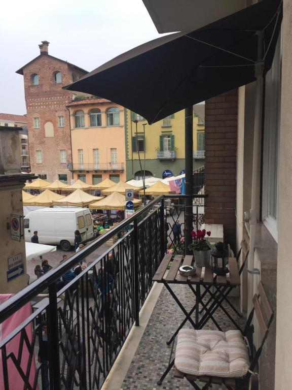 uma varanda com uma mesa e um guarda-chuva em Lilly Rose Apartment em Alba