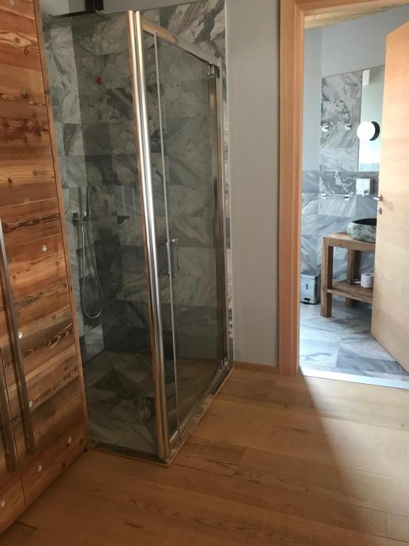 a shower with glass doors in a room at Aux Pieds du Roi - Suite & Spa in Breuil-Cervinia