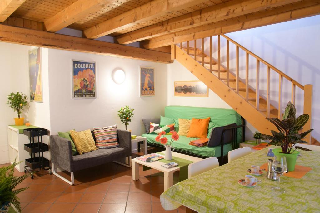 sala de estar con sofá verde y escalera en Casa al Pozzo en Riva del Garda