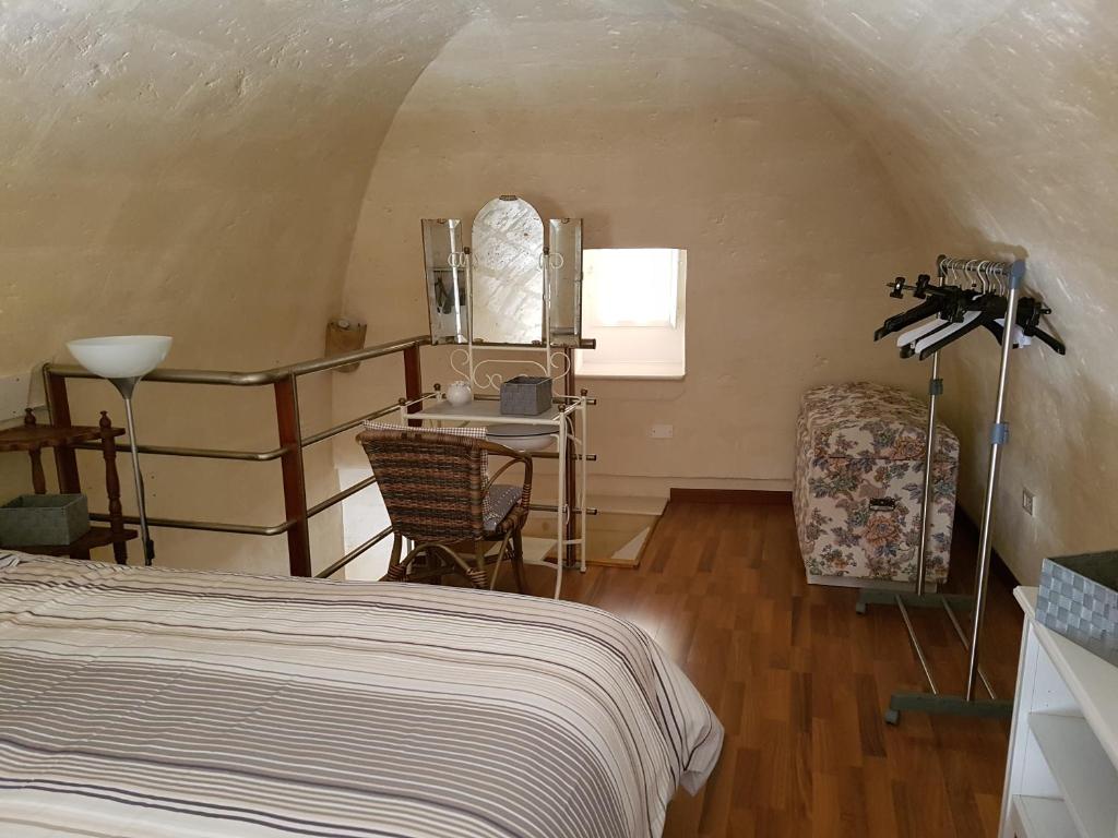 a bedroom with a bed and a table and a chair at Casa Elena in Matera
