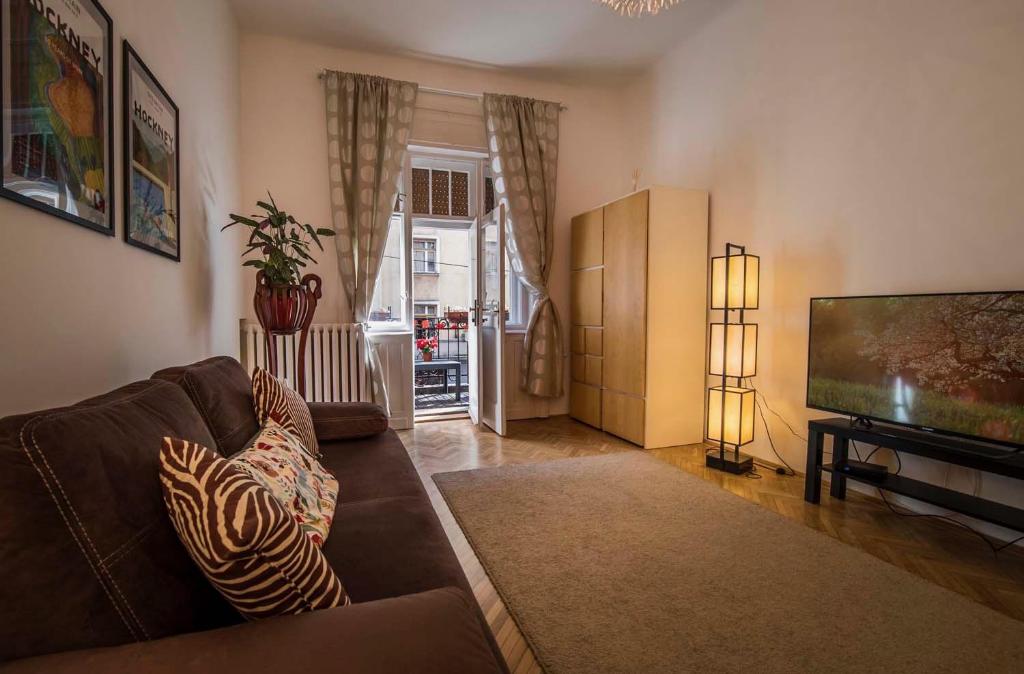 ein Wohnzimmer mit einem Sofa und einem Flachbild-TV in der Unterkunft Lovely flat near the Danube in Budapest