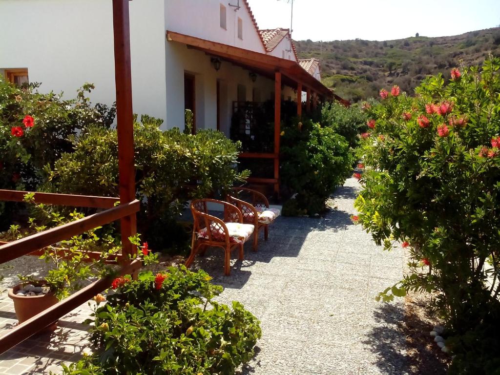 a garden with chairs and flowers in front of a building at Drakano Rooms in Fanari