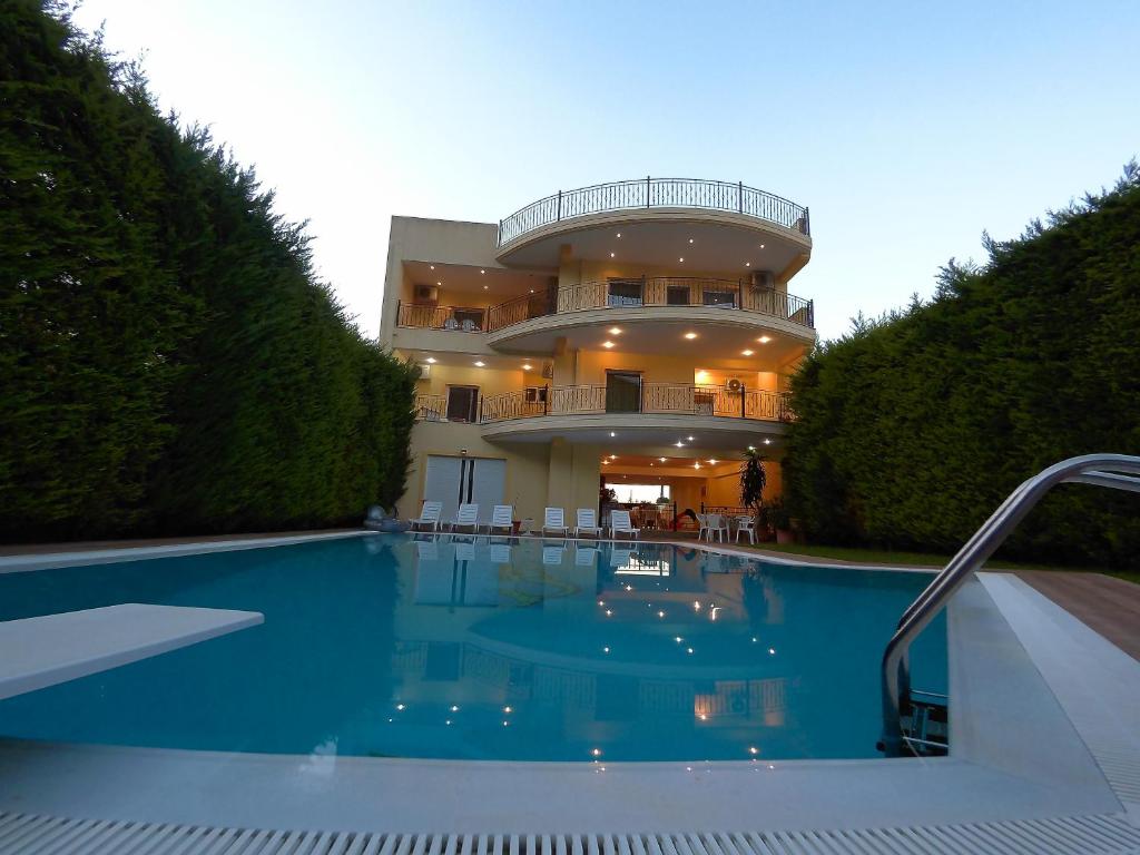 a house with a swimming pool in front of a building at Diamond Apartments in Agios Konstantinos Fthiotida