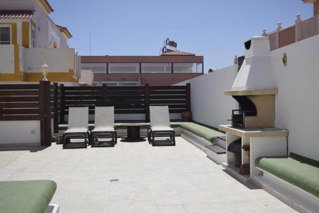 カレタ・デ・フステにあるSol y Luna en Caleta de Fusteの屋上のパティオ(椅子、テーブル付)