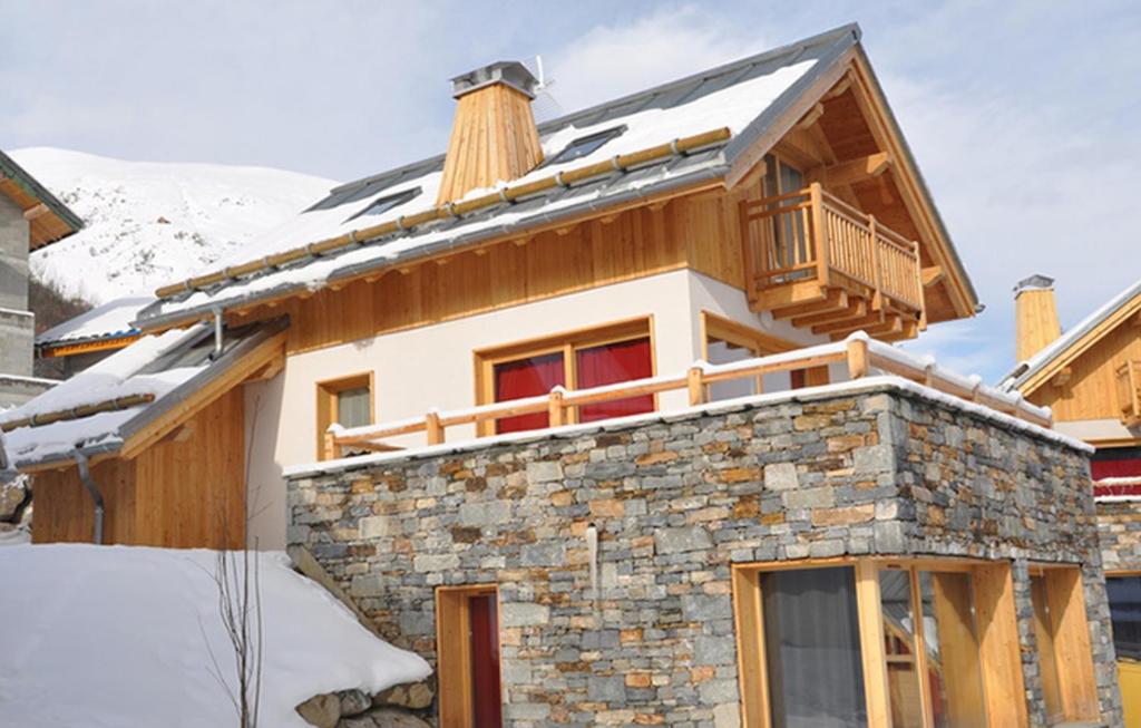 une maison dans la neige avec un balcon dans l'établissement Odalys Chalet Le Mas des Neiges, à Valloire