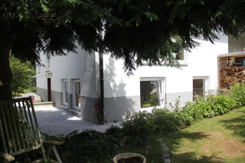 ein weißes Haus mit einem Baum davor in der Unterkunft Nürnberg Business Apartment in Heroldsberg