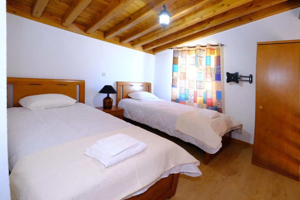 1 dormitorio con 2 camas y ventana en Quinta do Fragoso, en Alto do Sul