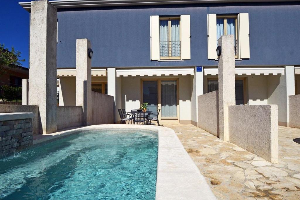 a house with a swimming pool in front of a house at Villa Blue 1 in Banjole