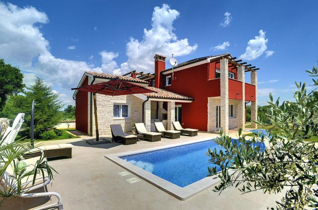 een villa met een zwembad en een huis bij Villa Delle Rondini in Krnica