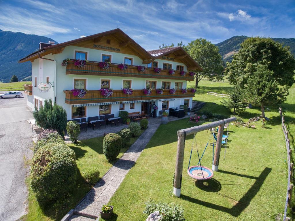 een groot gebouw met een speeltuin ervoor bij Hotel-Pension Das Platzl in Schladming