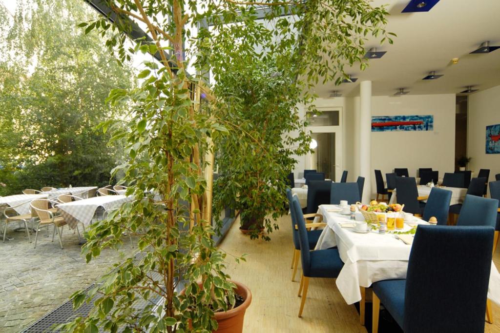 un restaurante con mesas, sillas y macetas en Gästehaus Klinglhuber, en Krems an der Donau
