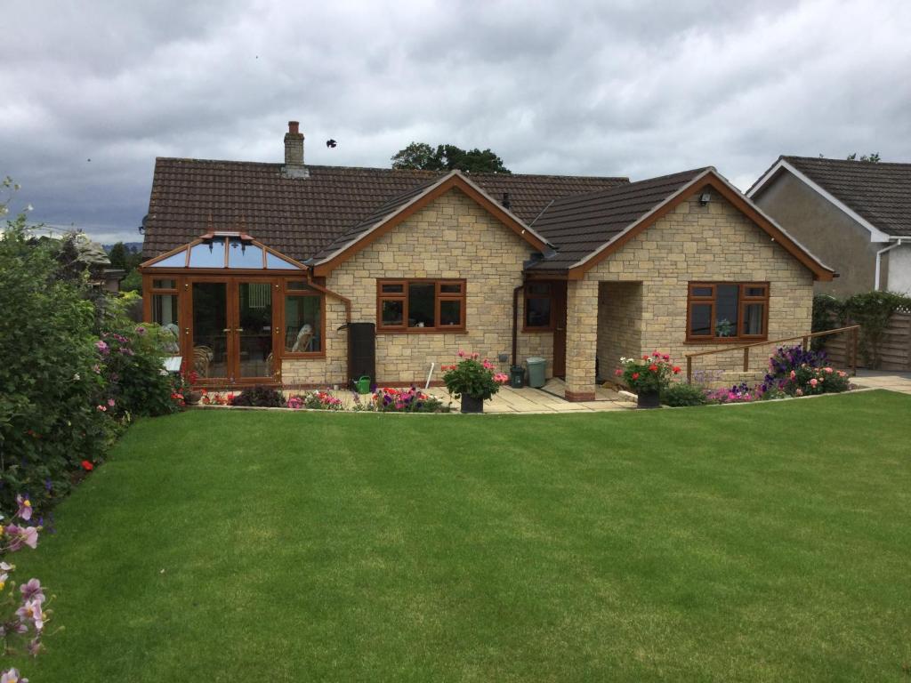 a house with a green lawn in front of it at Carinya in Talgarth