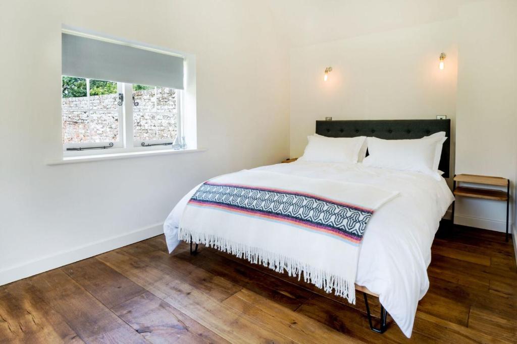 um quarto com uma grande cama branca e uma janela em The Workshop @ The Grange em Lydd