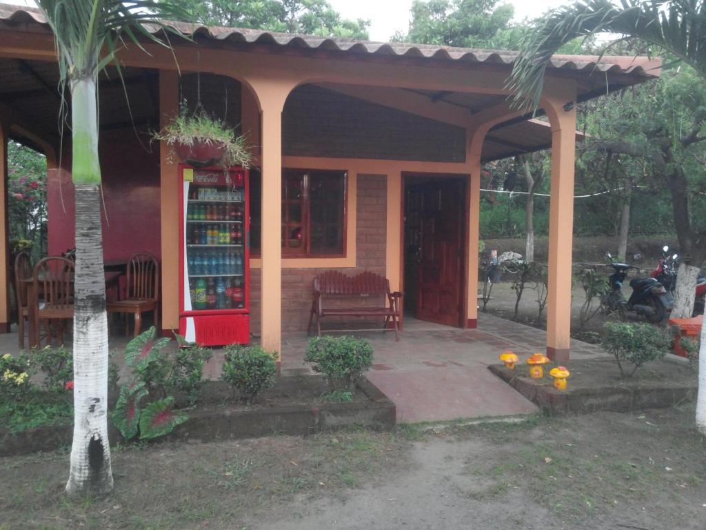 uma pequena casa com um banco e uma estante de livros em Hotel California em San Jorge