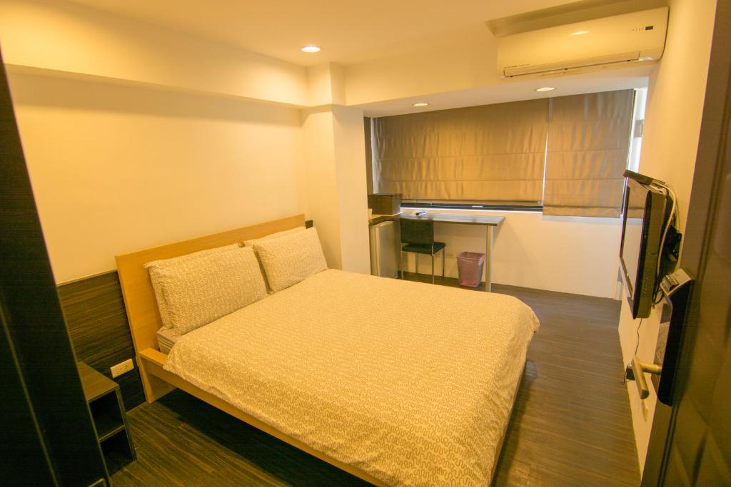 um pequeno quarto com uma cama e uma cozinha em Zhongxiao Dunhua Homestay em Taipei