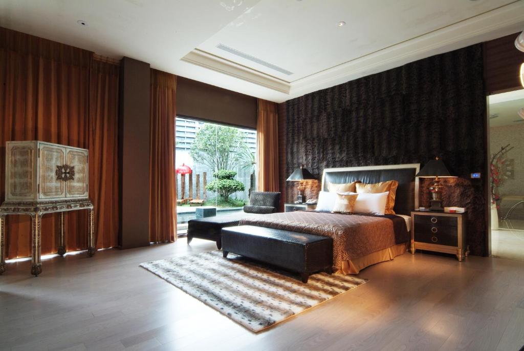 a bedroom with a bed and a large window at Lu Kang Villa Spa in Lugang