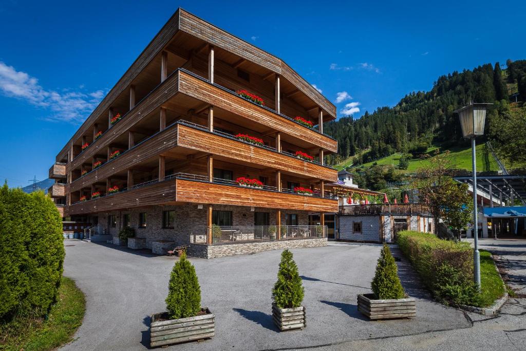 duży budynek z drzewami przed nim w obiekcie Aktivhotel Tuxerhof w mieście Zell am Ziller