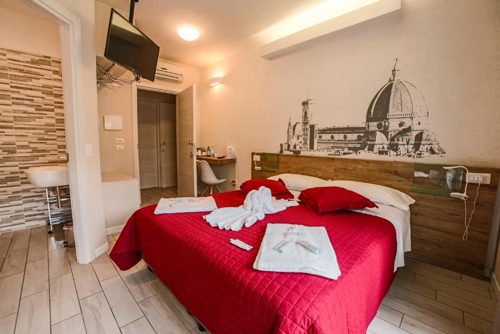 Un dormitorio con una cama roja con toallas. en B&B Santa Maria Novella, en Florencia