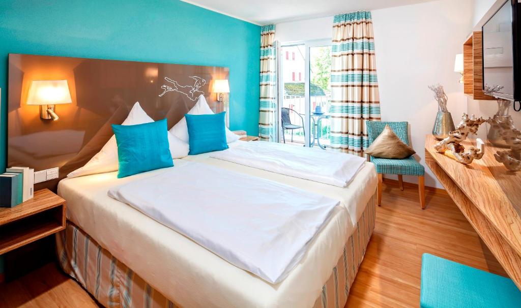 Hotel Schönau في لينداو: غرفة نوم بسرير كبير بجدران زرقاء