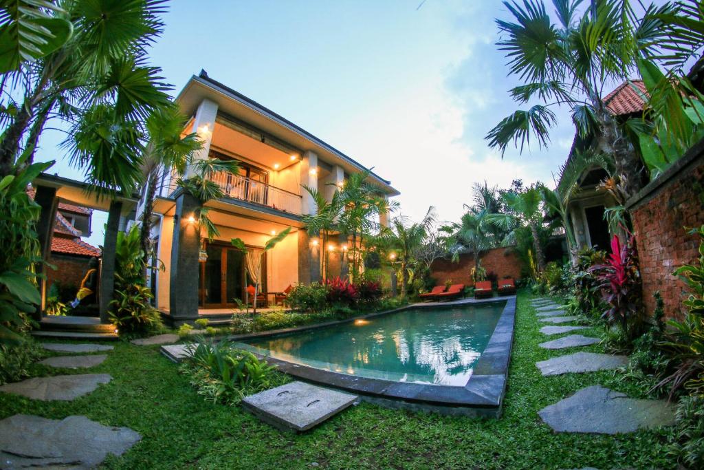 eine Villa mit einem Pool vor einem Haus in der Unterkunft Cahyatika Bed & Breakfast in Ubud